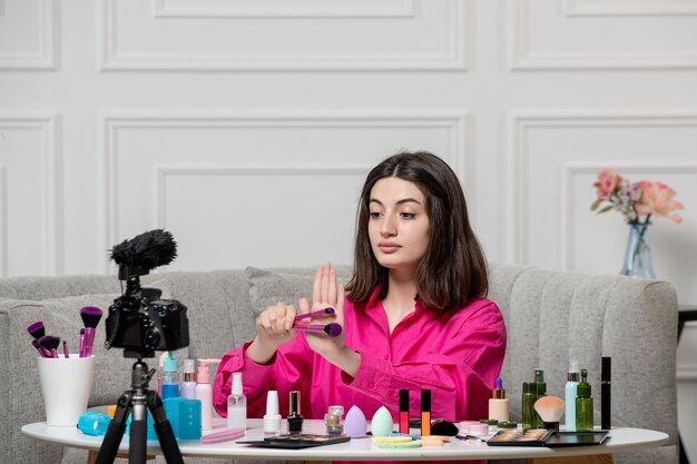 Make-up blogger schattige mooie mooie jonge dame die video opneemt op camera met borstels