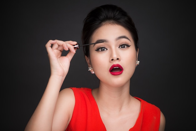 Make-up en cosmetica concept. aziatische vrouw doet haar make-up wimpers zwarte mascara.
