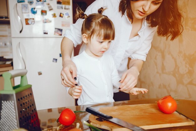 Mam samen met haar dochter kookt groenten thuis in de keuken