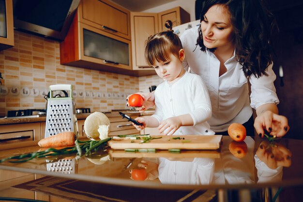 Mam samen met haar dochter kookt groenten thuis in de keuken