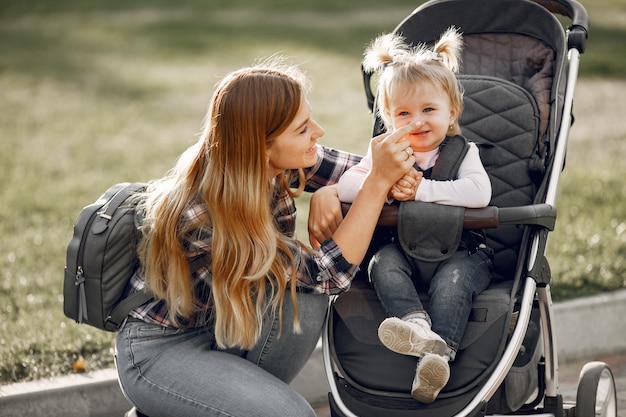 Mama op straat in de stad. Vrouw met haar peuterzitting in een kinderwagen. Familie concept.