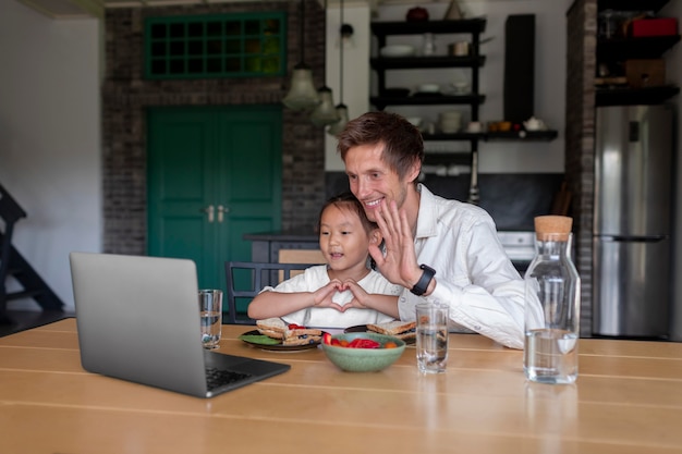 Man aan het videobellen met zijn vrouw naast hun dochter