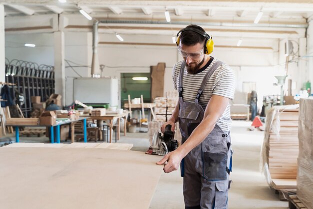 Man aan het werk aan het snijden van mdf-plaat