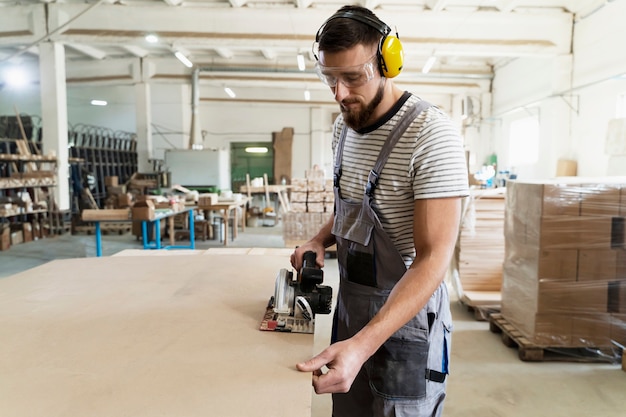 Man aan het werk aan het snijden van mdf-plaat