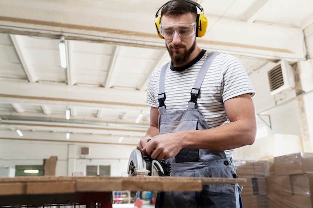 Gratis foto man aan het werk aan het snijden van mdf-plaat