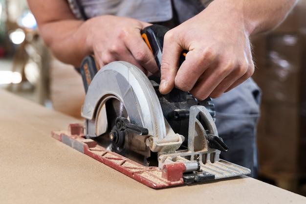 Man aan het werk aan het snijden van mdf-plaat