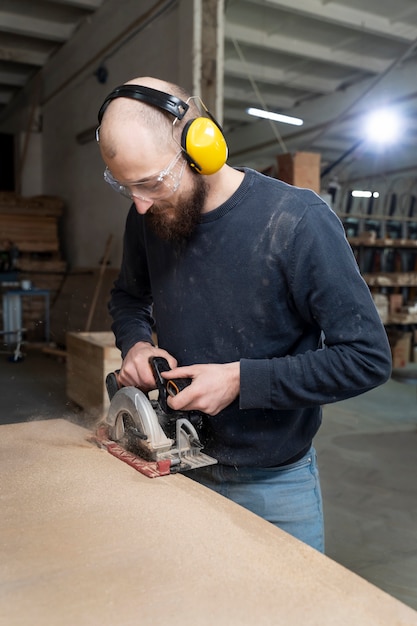 Gratis foto man aan het werk aan het snijden van mdf-plaat