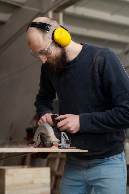 Gratis foto man aan het werk aan het snijden van mdf-plaat