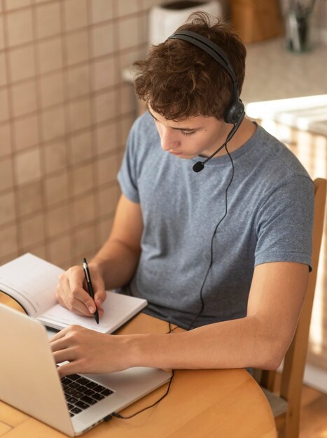 Man aan het werk in de keuken thuis tijdens quarantaine met laptop