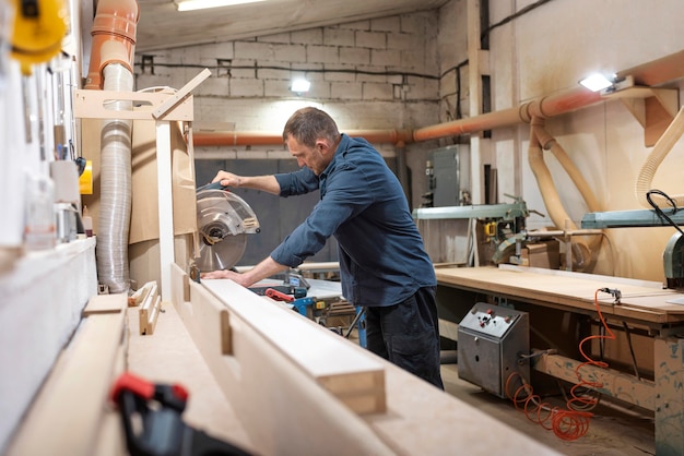 Gratis foto man aan het werk in een houten werkplaats