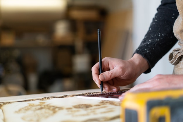 Man aan het werk in een houtgravure-atelier