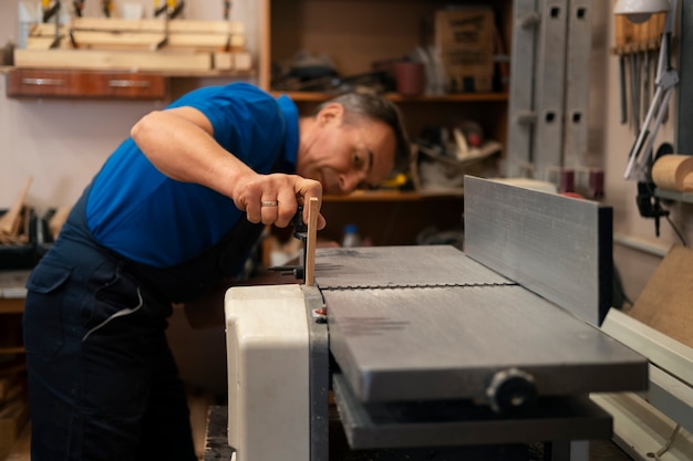 Man aan het werk in zijn houtwinkel met gereedschap en uitrusting