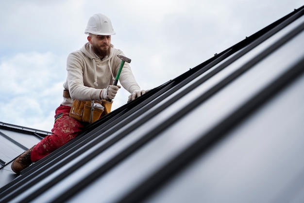 Man aan het werk op dak met hamer volledig schot
