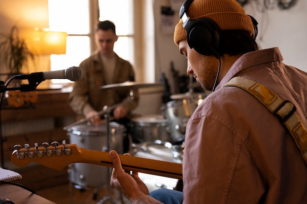 Gratis foto man aan het werk op muziek in de studio met instrumenten