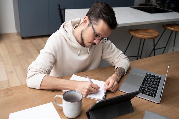 Man aan het werk vanuit huis aan bureau met laptop