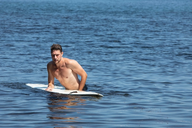 Man alleen surfen in de oceaan met kopieerruimte