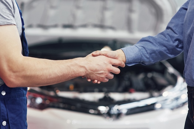 Man automonteur en vrouw klant maken een afspraak over de reparatie van de auto
