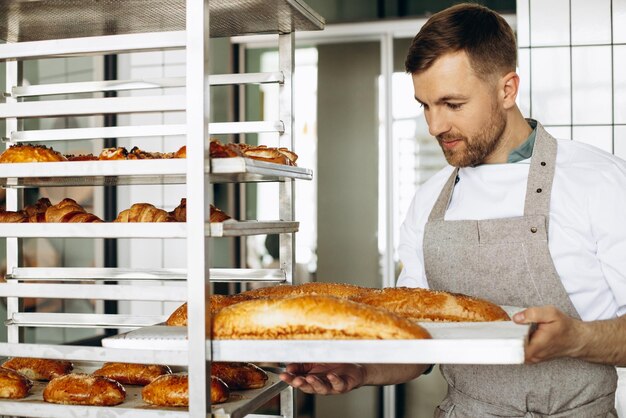 Man bakker met vers brood bij bakkershuis