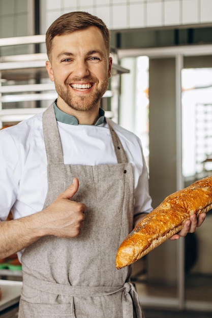 Man bakker met vers brood bij bakkershuis