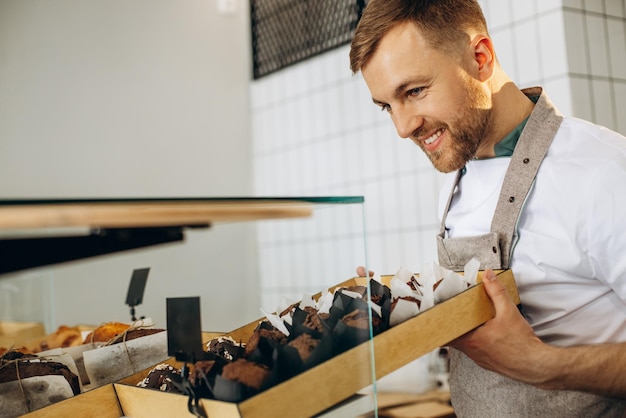 Man bakker zet chocoladecakes op het aanrecht