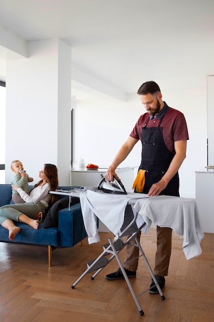 Man bediende kleding strijken