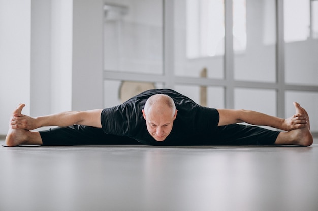 Man beoefenen van yoga in de sportschool