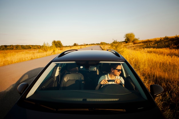 Gratis foto man besturen van een zwarte auto