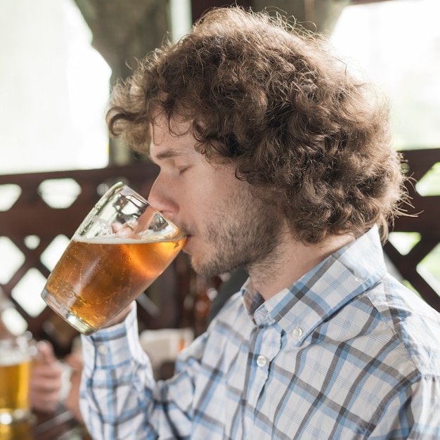 Gratis foto man bier drinken met gesloten ogen