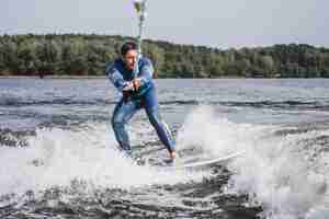 Gratis foto man bij het wakesurfen. zwaai van de boot.