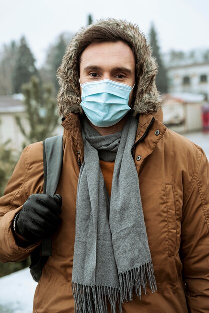 Man buiten in de winter medische masker dragen