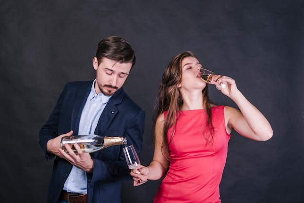 Man champagne gieten in glas terwijl vrouw drinken