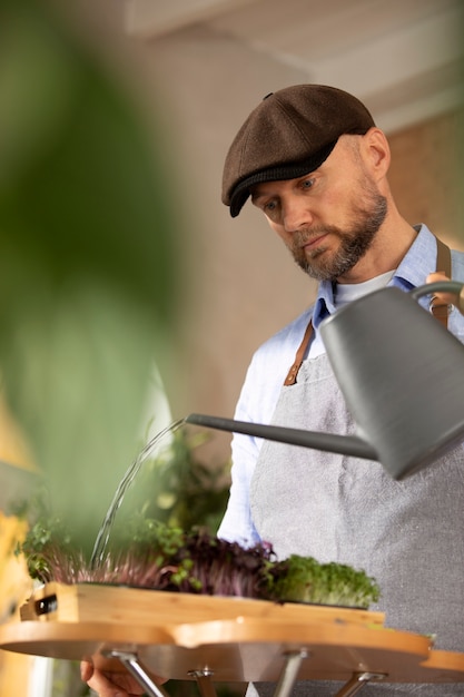 Gratis foto man cultiveert en kweekt planten in een binnentuin