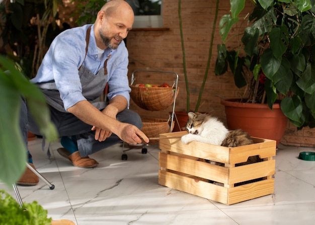 Gratis foto man cultiveert en kweekt planten in een binnentuin