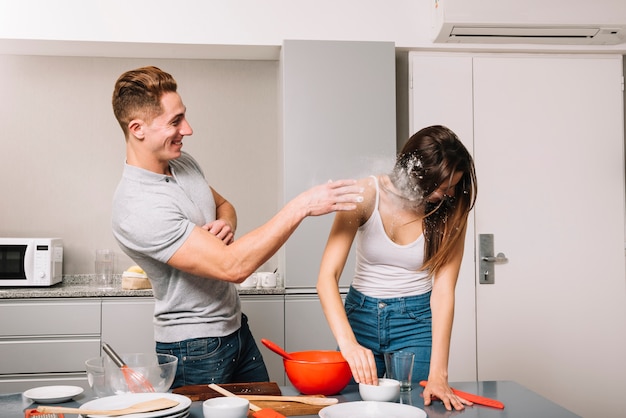 Man die bloem in vrouw in keuken werpen