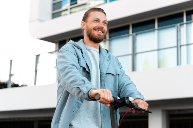 Man die buiten op een milieuvriendelijke scooter rijdt