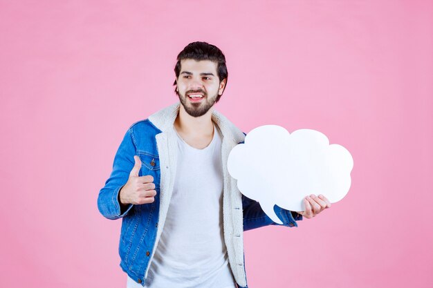 Man die een leeg denkbord in de vorm van een wolk vasthoudt en zich een winnaar voelt