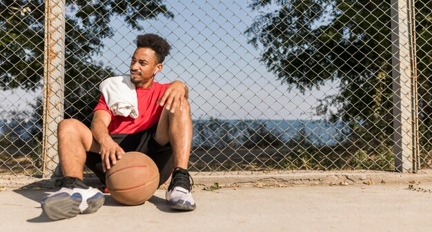 Man die een pauze neemt na een basketbalspel met kopie ruimte