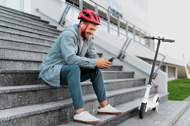 Man die een pauze neemt na het rijden op zijn scooter