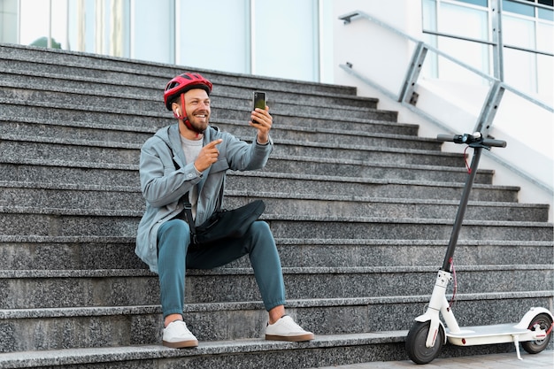 Man die een pauze neemt na het rijden op zijn scooter