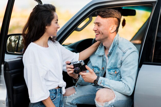 Man die een retro camera houdt en zijn vriendin bekijkt