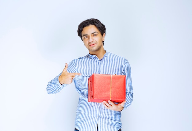 Man die een rode geschenkdoos vasthoudt of aanbiedt aan zijn vriendin. Hoge kwaliteit foto