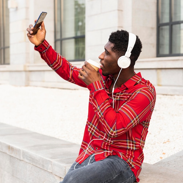 Man die een selfie neemt en naar muziek luistert