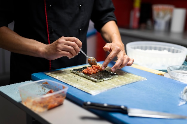 Man die een sushi-bestelling klaarmaakt voor een afhaalmaaltijd