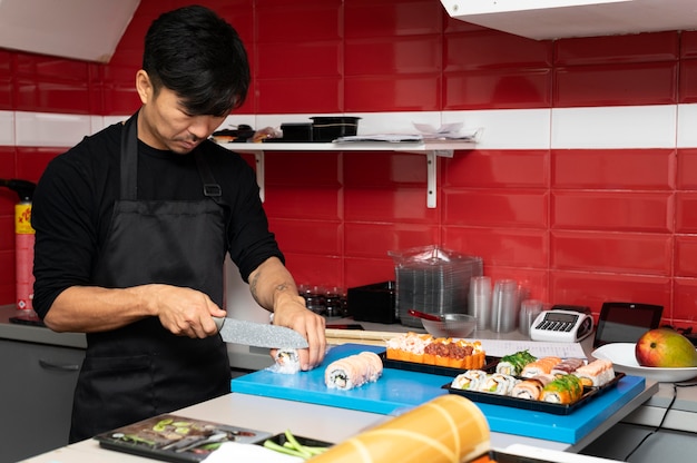 Man die een sushi-bestelling klaarmaakt voor een afhaalmaaltijd