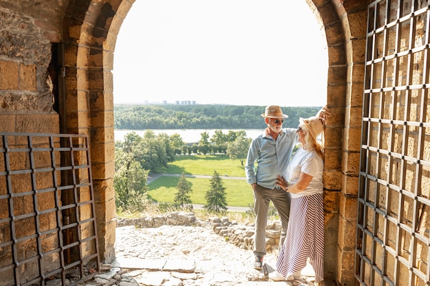 Gratis foto man die een vrouw bekijkt die tegen een muur leunt