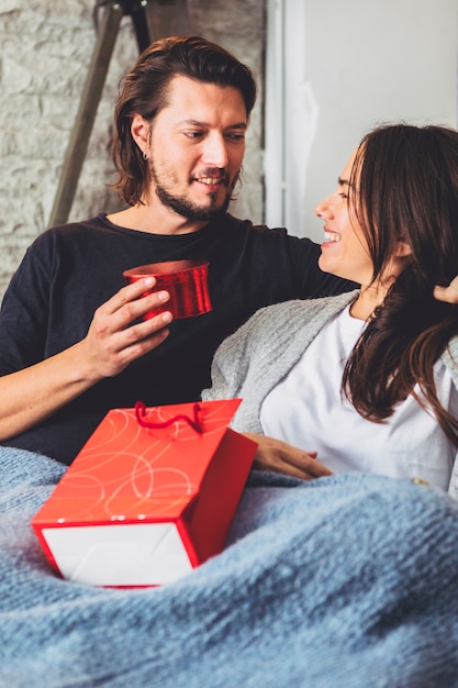 Gratis foto man die giftdoos geeft aan vrouw op laag