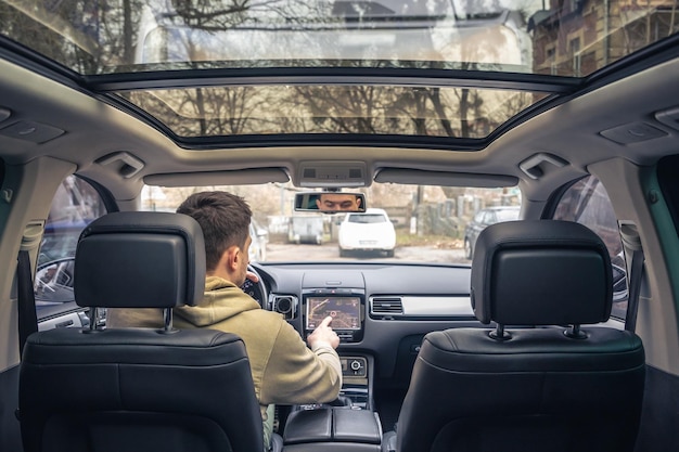 Man die het scherm van een gps-navigatiesysteem in zijn auto aanraakt