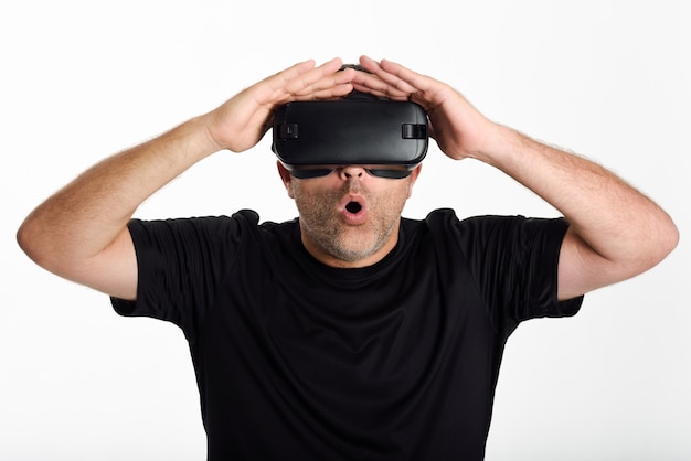 Man die in VR-glazen kijkt en met zijn handen brengt.