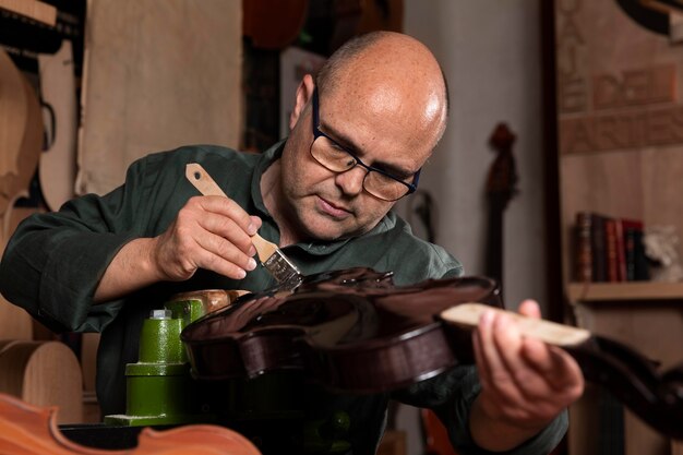 Man die instrumenten maakt in zijn atelier alleen