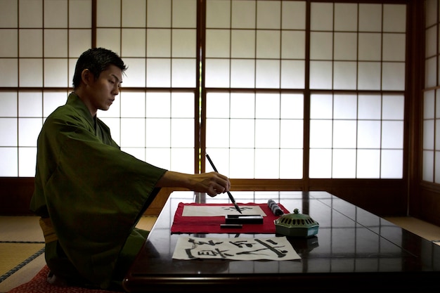 Man die japans handschrift oefent met een penseel